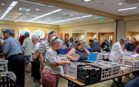 Library patrons browsing the large selection at one of the previous FOL booksales. 